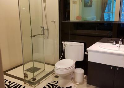 Modern bathroom with glass shower, toilet, and sink