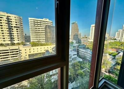 View of the cityscape through a window in a high-rise building