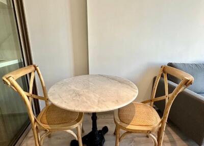 Small dining area with round marble table and wooden chairs