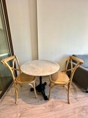 Small dining area with round marble table and wooden chairs