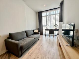 Modern living room with sofa, desk, and TV