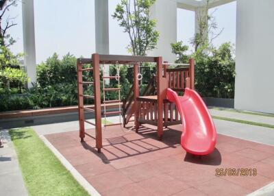 Outdoor playground with red slide and climbing structures