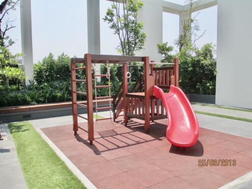 Outdoor playground with red slide and climbing structures