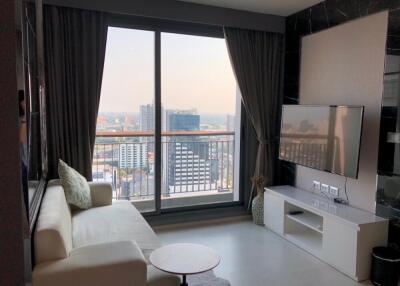 Living room with city view, balcony window, and a TV