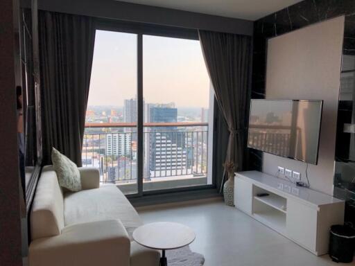 Living room with city view, balcony window, and a TV