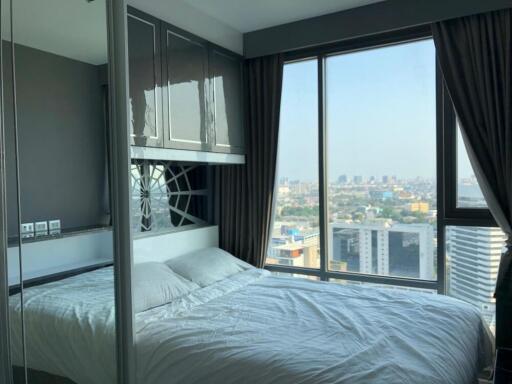 Modern bedroom with large windows and city view