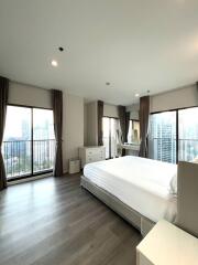 Spacious bedroom with large windows and city view