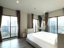 Spacious bedroom with large windows and city view