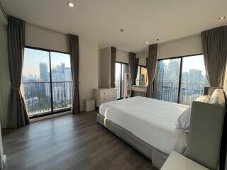 Spacious bedroom with large windows and a city view