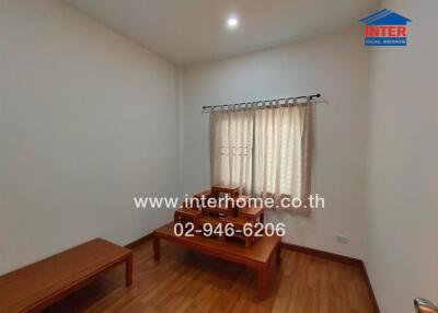 Small bedroom with wooden furniture and a window with curtains