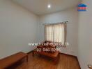 Small bedroom with wooden furniture and a window with curtains