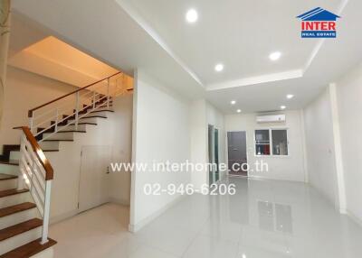 Bright main living area with staircase and modern fixtures