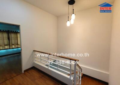 Hallway with modern light fixtures and wooden flooring