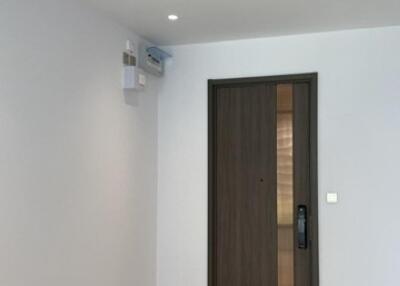 Minimalist main living space with doorway, light-colored flooring, and ceiling air conditioning unit