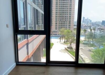 Photo of a bedroom with large floor-to-ceiling windows overlooking a cityscape