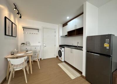 Modern kitchen and dining area with a washing machine and fridge