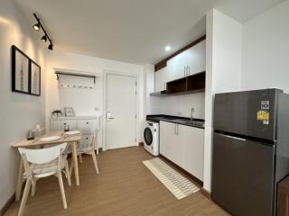 Modern kitchen and dining area with a washing machine and fridge