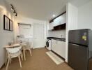 Modern kitchen and dining area with a washing machine and fridge