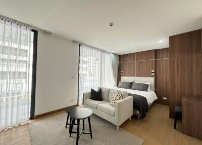 Bedroom with seating area and large windows