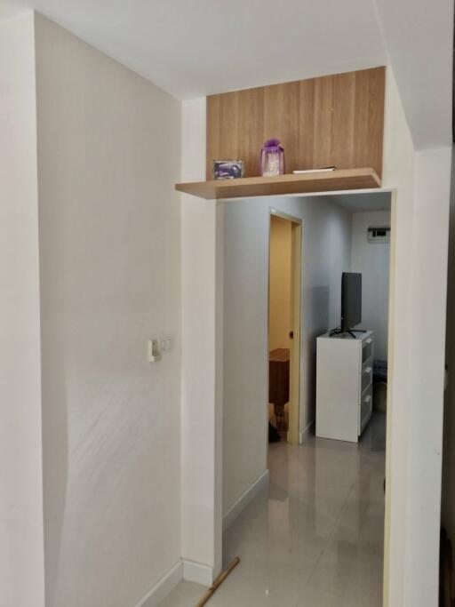 View of a hallway leading into a room with furniture