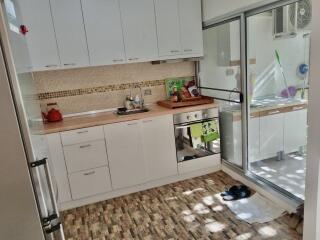 Modern kitchen with white cabinets and wooden countertops