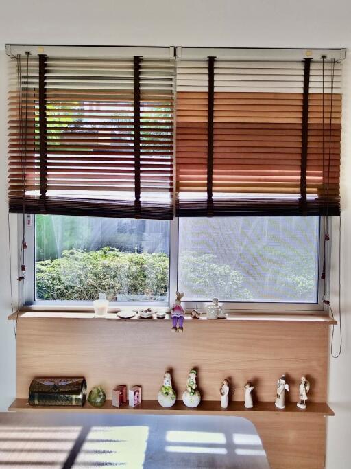 Bedroom window with wooden blinds and decorative items on the windowsill