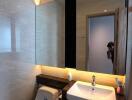 Modern bathroom with large mirror and lighting