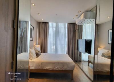 Modern bedroom with floor-to-ceiling windows and mirrored wardrobe