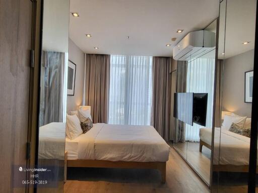 Modern bedroom with floor-to-ceiling windows and mirrored wardrobe