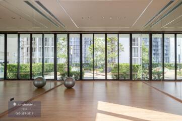 Spacious room with large windows and exercise balls