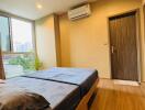 Modern bedroom with wooden flooring and large window