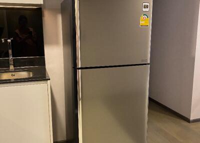 Modern kitchen area with stainless steel refrigerator