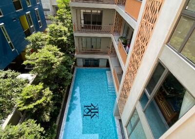 Aerial view of a modern apartment building with a swimming pool