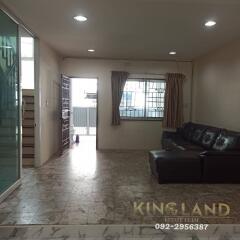 Main living space with sofa, window, and tiled floors