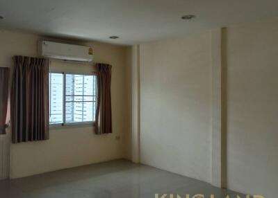 Vacant living area with a window, air conditioner, and tiled flooring