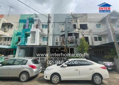 Front view of a residential building with parked cars