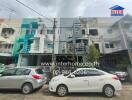 Front view of a residential building with parked cars