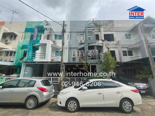 Front view of a residential building with parked cars