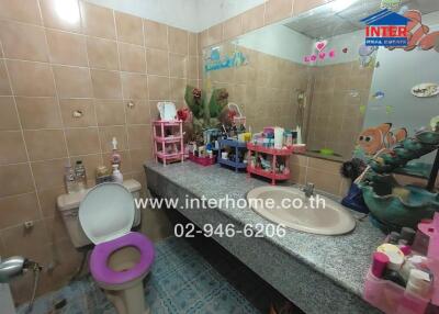 Bathroom with tiled walls, single vanity, and decorated surfaces