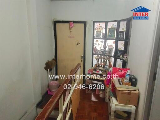 Hallway with storage items and a decorative door