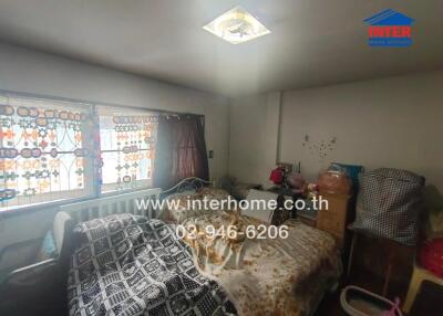 Photo of a bedroom with decorated windows, bed, and assorted items