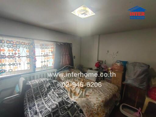 Photo of a bedroom with decorated windows, bed, and assorted items