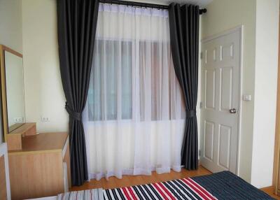 Bedroom with window, curtains, and bed