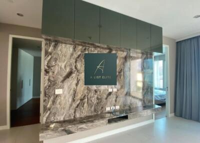 Modern living area with built-in cabinetry and marble wall design