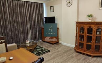 Spacious living room with wooden furniture and a TV