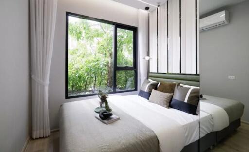 Modern bedroom with large window and greenery view