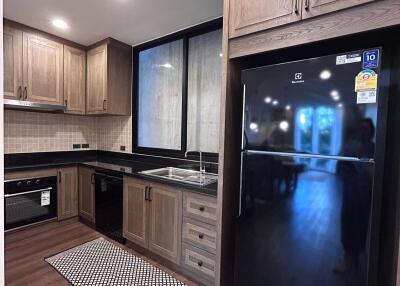 Modern kitchen with wooden cabinets and black appliances