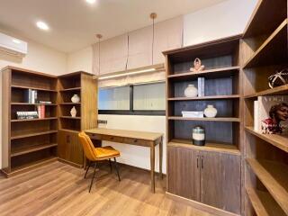 Modern home office with built-in wooden shelves and desk