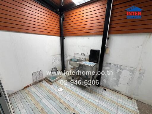 Covered patio area with sink and wooden slat ceiling