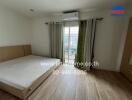 Spacious bedroom with bed, large window, and air conditioning unit